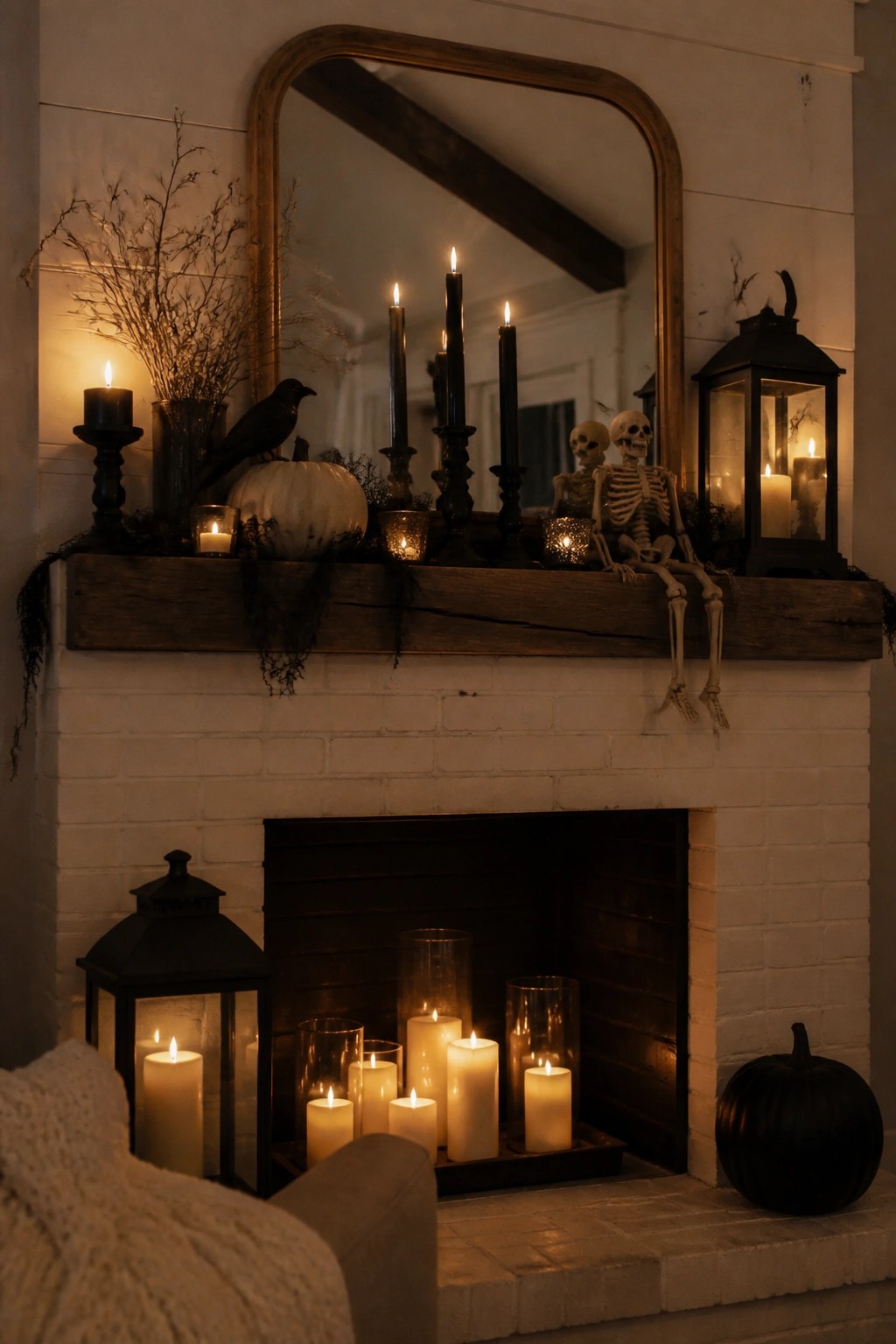 White brick fireplace with a rustic wooden mantel holding two skeletons, black taper candles, a white pumpkin, a black crow, and several lanterns.