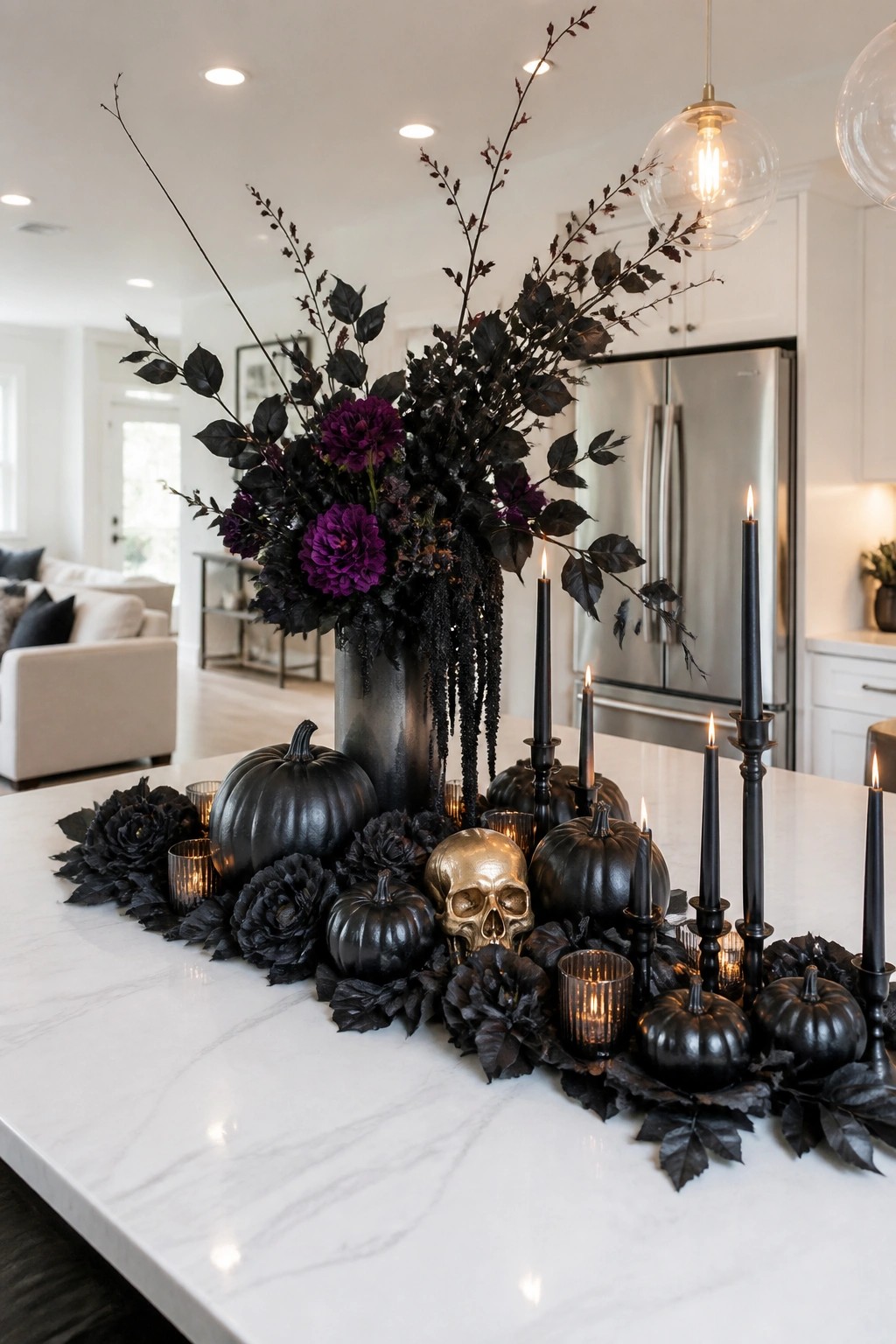 Kitchen island centerpiece with a gold skull, black branches, purple flowers, black pumpkins, and lit black candles on a white marble surface.