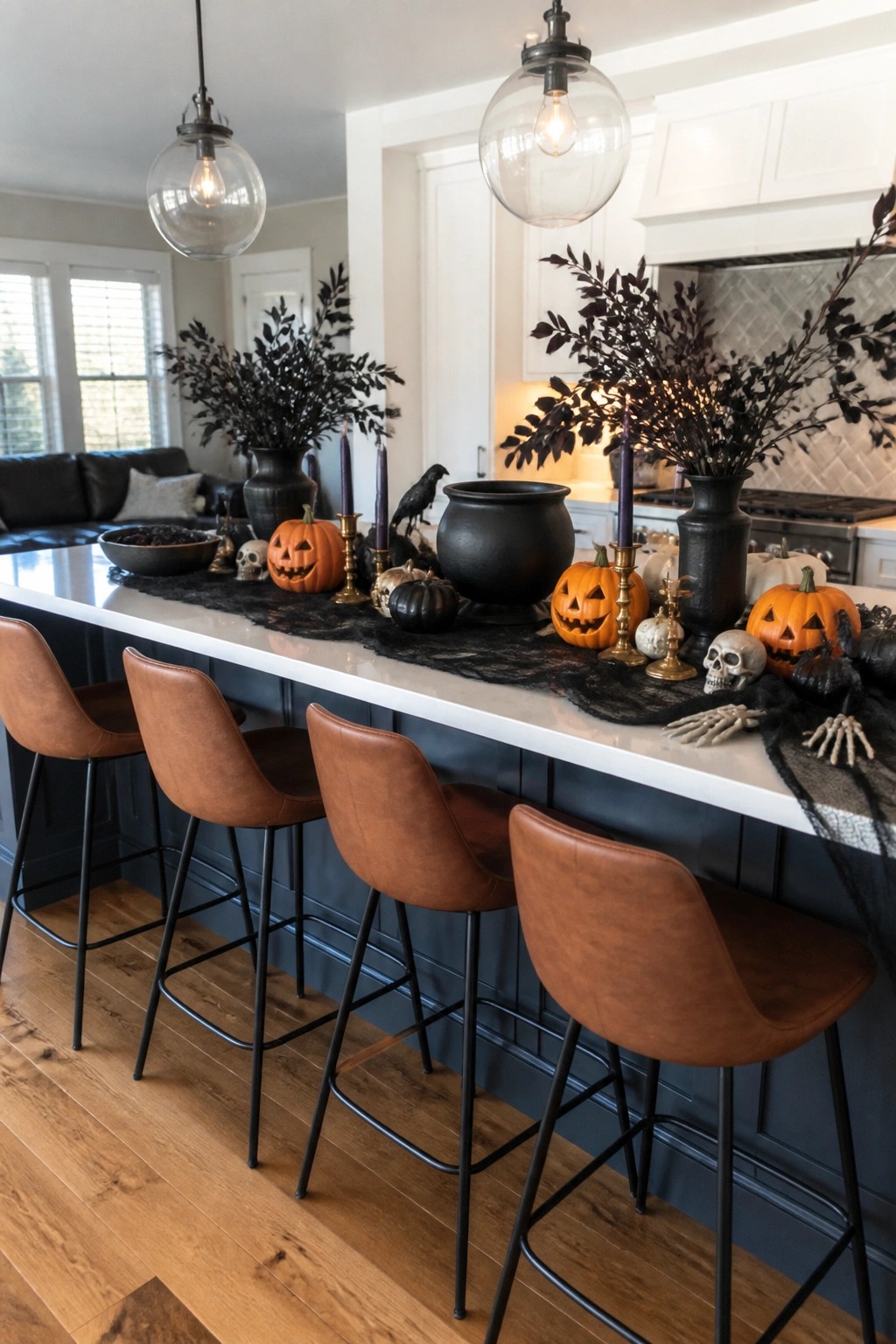 Kitchen island with carved jack o lanterns, skulls, a black cauldron, and purple candles arranged on a black lace runner.
