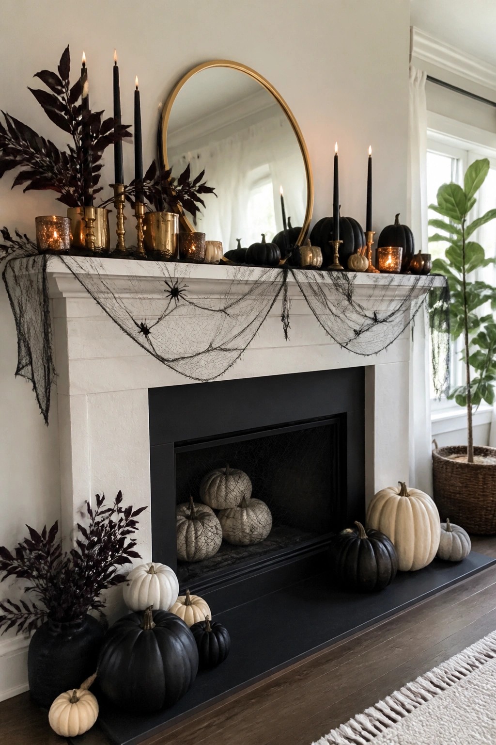 White fireplace mantel with black spiderwebs and spiders draped across it, black taper candles, and black and white pumpkins arranged on the mantel and hearth.